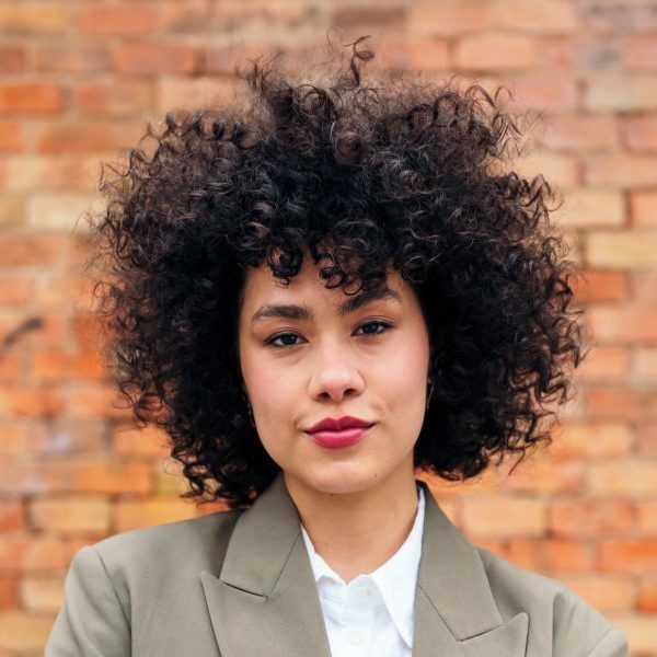 Young woman looking at camera with arms folded e1683169180197.jpg
